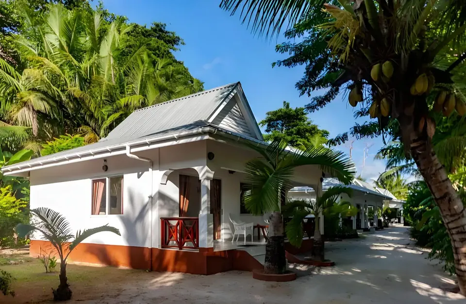 Eine Villa mit einer Palme an der Ecke und einem Weg zwischen den anderen Villen